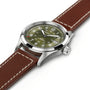 The Hamilton Khaki Field Auto 38mm is a stainless steel watch with military heritage, featuring an olive green dial, white numerals, date window, and a brown leather strap with white stitching.
