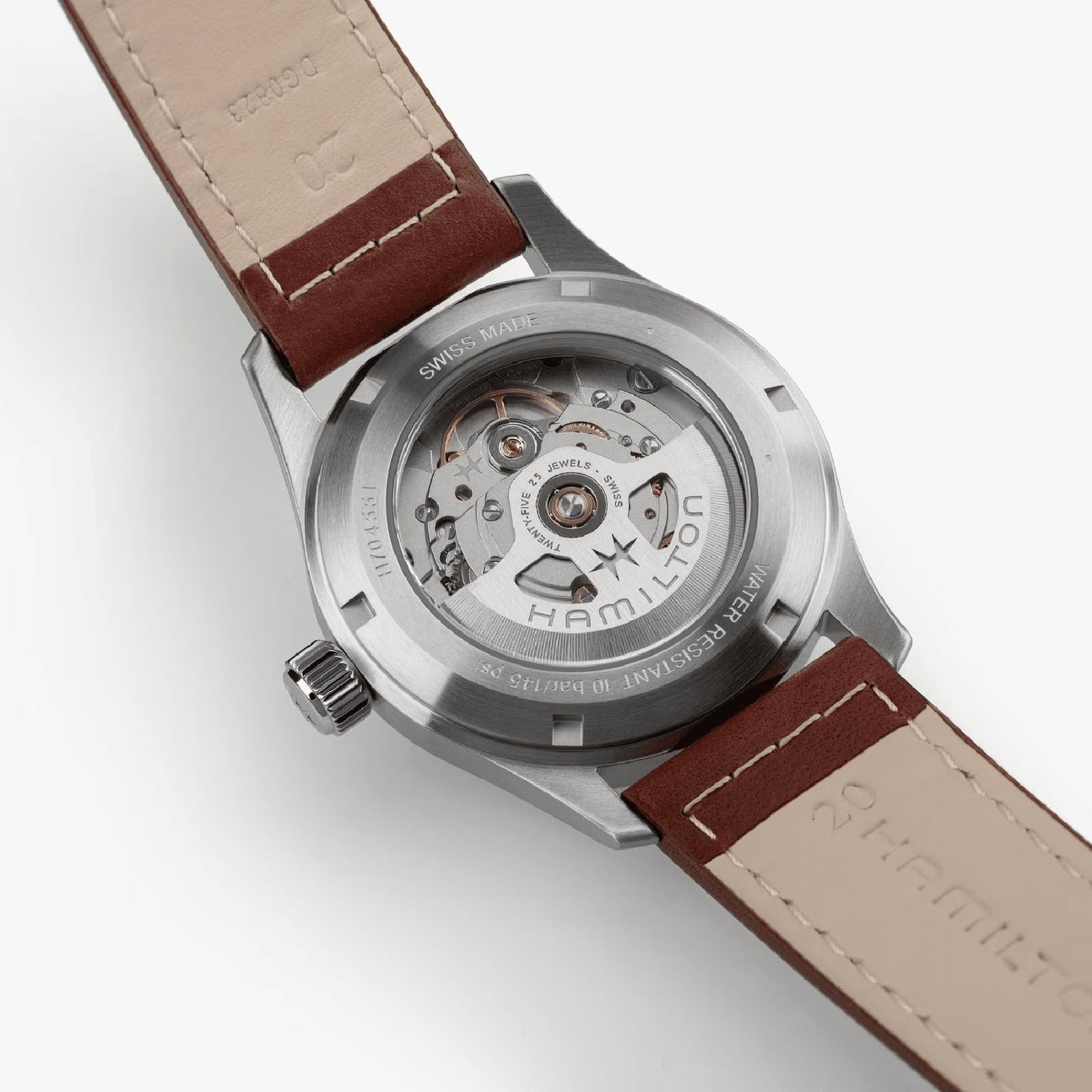 Back view of the Hamilton Khaki Field Auto 38mm shows its automatic movement and transparent case back, brown leather strap, and engraved branding—highlighting the military-inspired design.