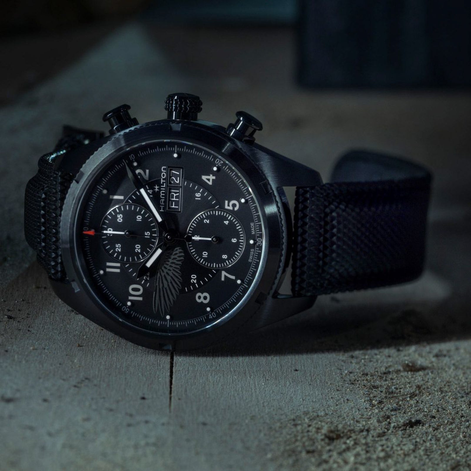 Black watch with detailed face on a textured surface