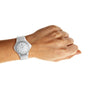A left hand with a light skin tone wears the Hublot Big Bang Steel White Diamonds wristwatch, featuring a stainless steel bezel, shown against a plain white background.