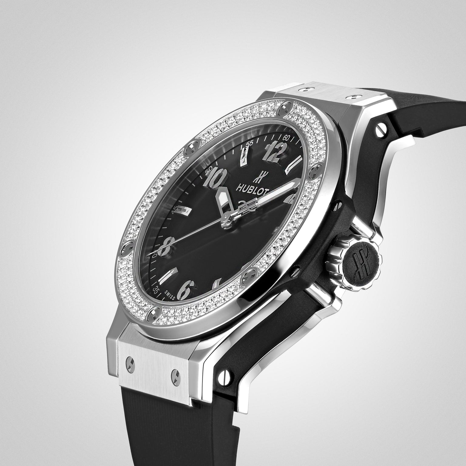 A close-up of the Hublot Big Bang Steel Diamonds watch featuring a black dial, diamond-encrusted bezel, stainless steel case, silver markers, and black rubber strap on a light gray background.