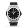 The Hublot Classic Fusion Titanium wristwatch features a black dial, silver indices, date at 3 oclock, titanium case, and black leather strap, shown against a white background.