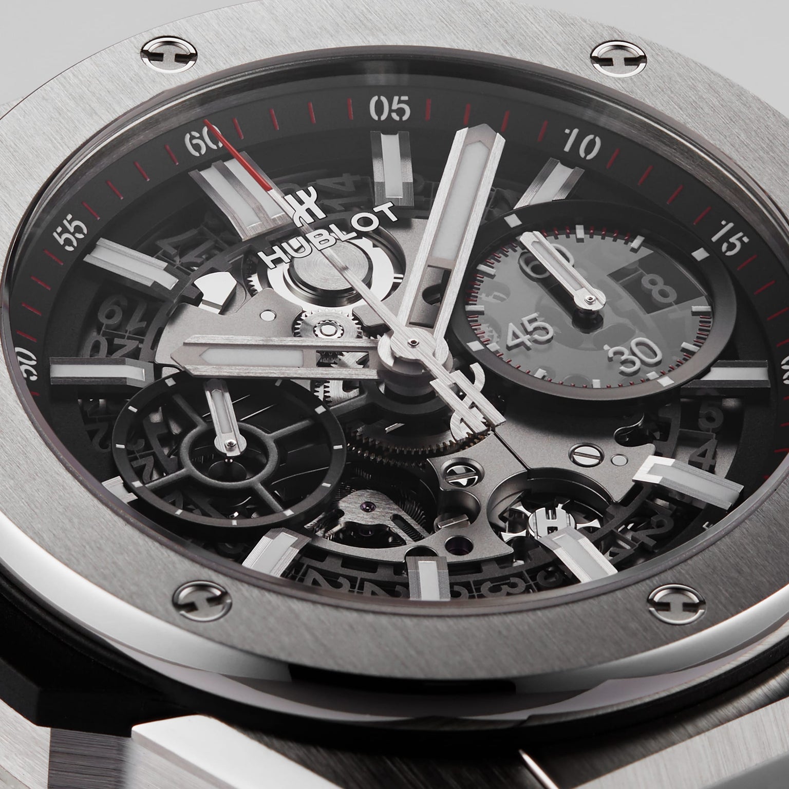 Close-up of the Hublot Big Bang Integrated Titanium watch, featuring a titanium case, skeleton dial with visible gears, chronograph subdial, and time markers.