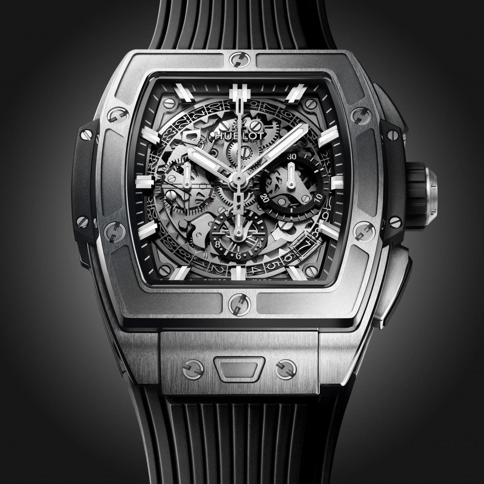 A close-up of the Hublot Spirit of Big Bang Titanium, featuring a square titanium case, skeleton dial, and black rubber strap.