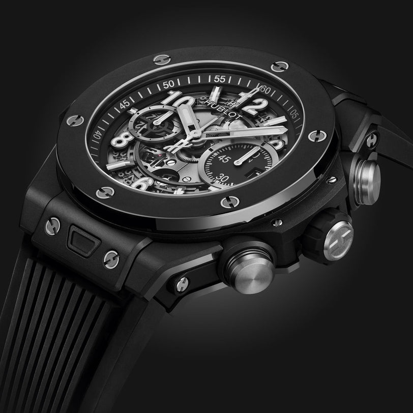 Close-up of the Hublot Big Bang Unico Black Magic, showcasing its UNICO movement, skeleton dial with visible mechanics, and textured side buttons—all highlighted against a dark background.