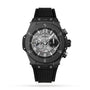 The Hublot Big Bang Unico Black Magic is a black wristwatch with a skeleton dial, visible gears, Arabic numerals, chronograph subdials, and a textured black rubber strap with self-winding chronograph movement.