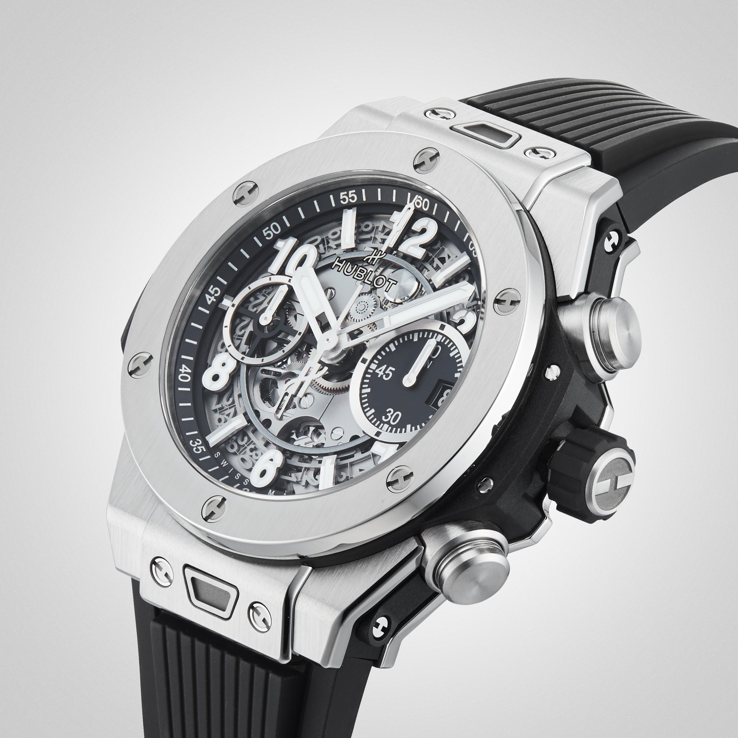 A close-up of the Hublot Big Bang Unico Titanium wristwatch featuring a skeleton dial, silver titanium case, visible gears, UNICO chronograph flyback movement, and a black rubber strap.