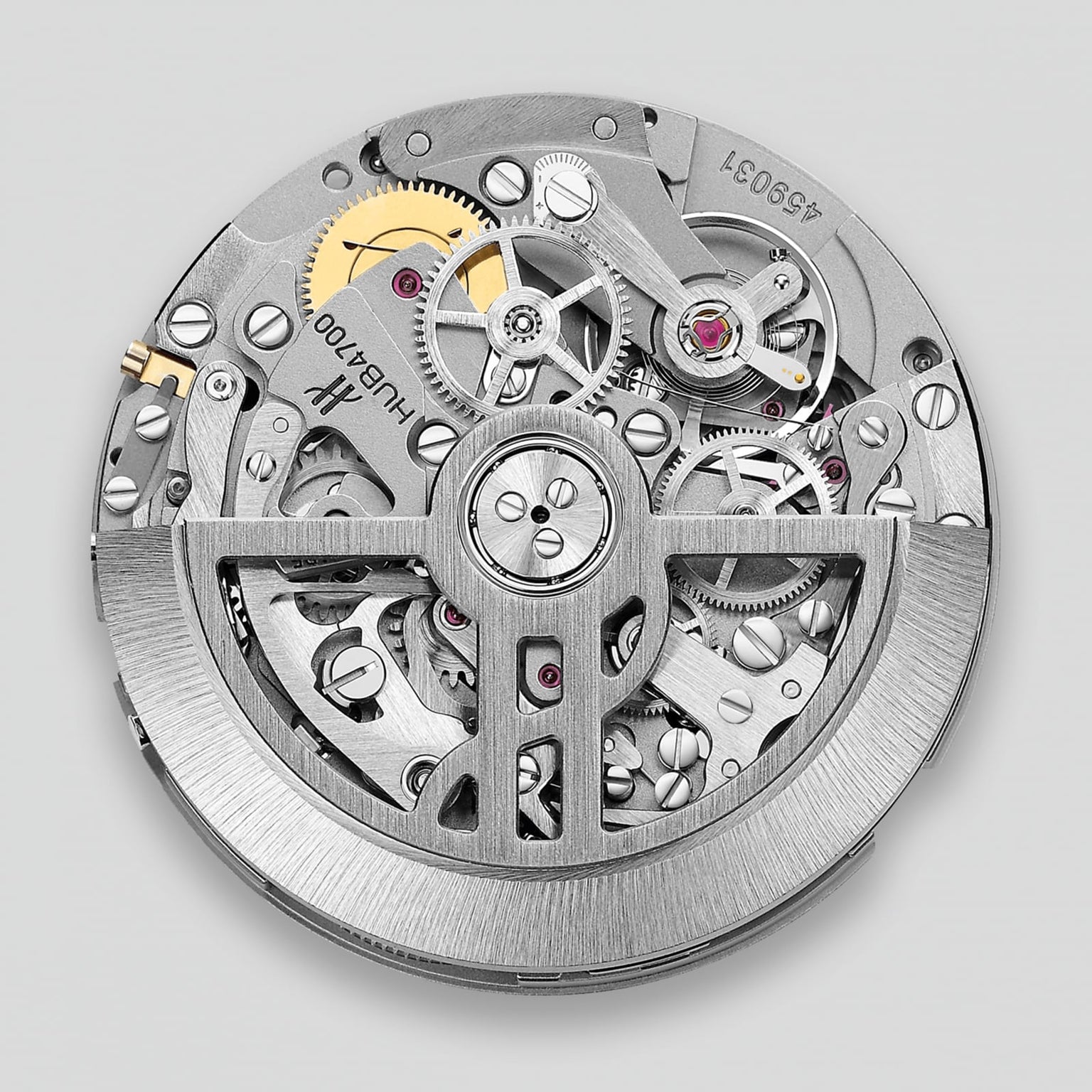 The Hublot Spirit Of Big Bang Magic Sapphire features a circular mechanical movement with visible gears and intricate metal details, all showcased beneath durable sapphire crystal on a brushed metal finish case against a plain background.