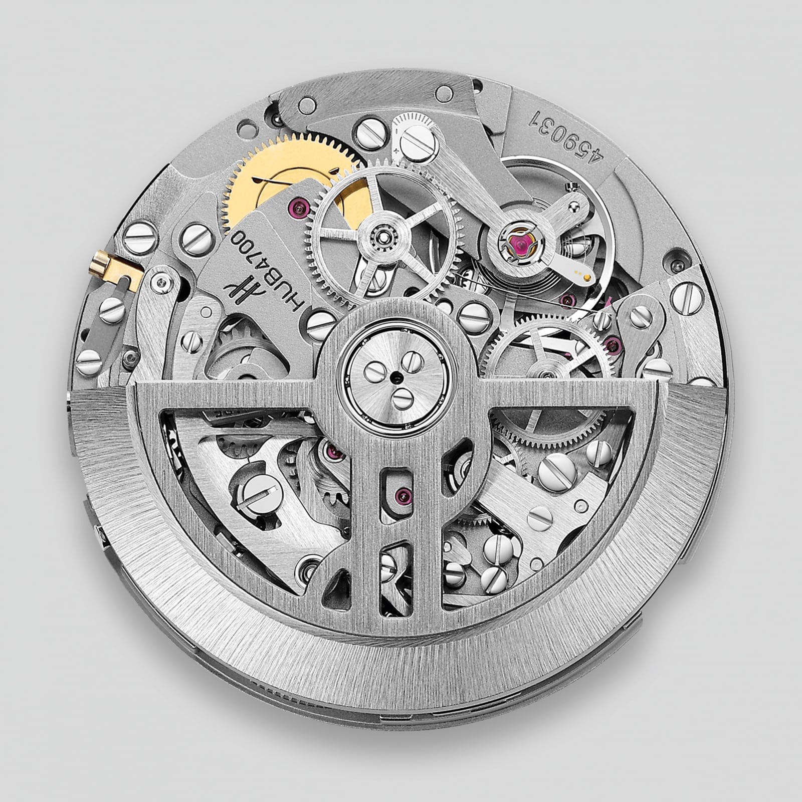 The Hublot Spirit Of Big Bang Magic Sapphire features a circular mechanical movement with visible gears and intricate metal details, all showcased beneath durable sapphire crystal on a brushed metal finish case against a plain background.