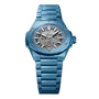 The Hublot Big Bang Integrated Time Only Sky Blue Ceramic is a blue ceramic wristwatch with a skeleton dial, visible gears, and silver hour markers and hands.
