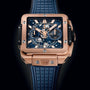 The Hublot Square Bang Unico King Gold Blue features a rose gold case, blue skeleton dial, blue rubber strap, exposed gears, and chronograph flyback subdials, set against a black background.