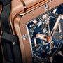 Close-up of Hublots Square Bang Unico King Gold Blue, showcasing its 18k King Gold case, blue dial, and exposed gears that highlight the timepiece’s intricate craftsmanship and mechanical details.