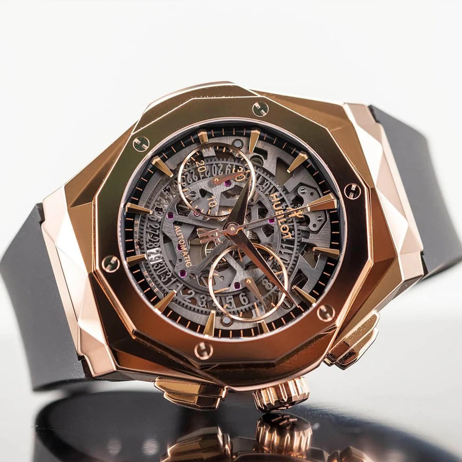 A close-up of the Hublot Classic Fusion Aerofusion King Gold wristwatch featuring a rose gold geometric case, skeleton dial, and black rubber strap, exemplifying modern luxury with its intricate internal mechanics.