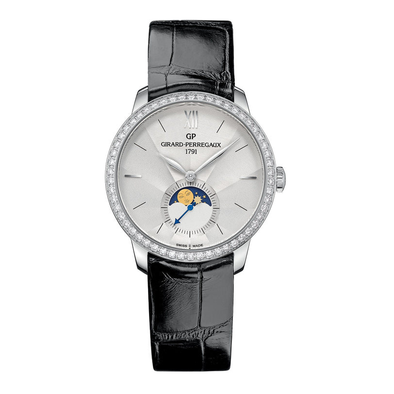 The Girard-Perregaux 1966 Moon Phases is a silver wristwatch with a diamond bezel, black leather strap, and moon phase indicator on the dial.