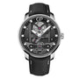 The Girard-Perregaux Free Bridge is a luxury wristwatch with a black textured strap, silver case, and exposed automatic movement on its black dial.