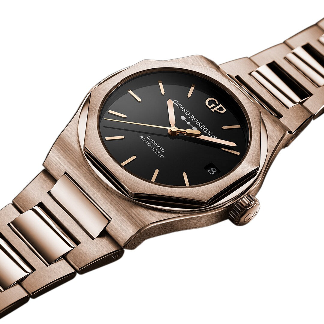 The Laureato 42 by Girard-Perregaux is a pink gold wristwatch with an octagonal bezel, black dial with gold hour markers and hands, date window at 3 o’clock, and a metal link bracelet.