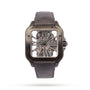 The Cartier Santos de Cartier Skeleton is a square watch with a visible mechanical movement, a gunmetal case, and a dark leather strap featuring the QuickSwitch interchangeability system.