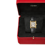 The Cartier Tank Louis Medium Model features a rectangular gold case, white dial with black Roman numerals, blue hands, and black leather strap, presented in an open red Cartier box with black velvet interior—reflecting Louis Cartier's legacy.