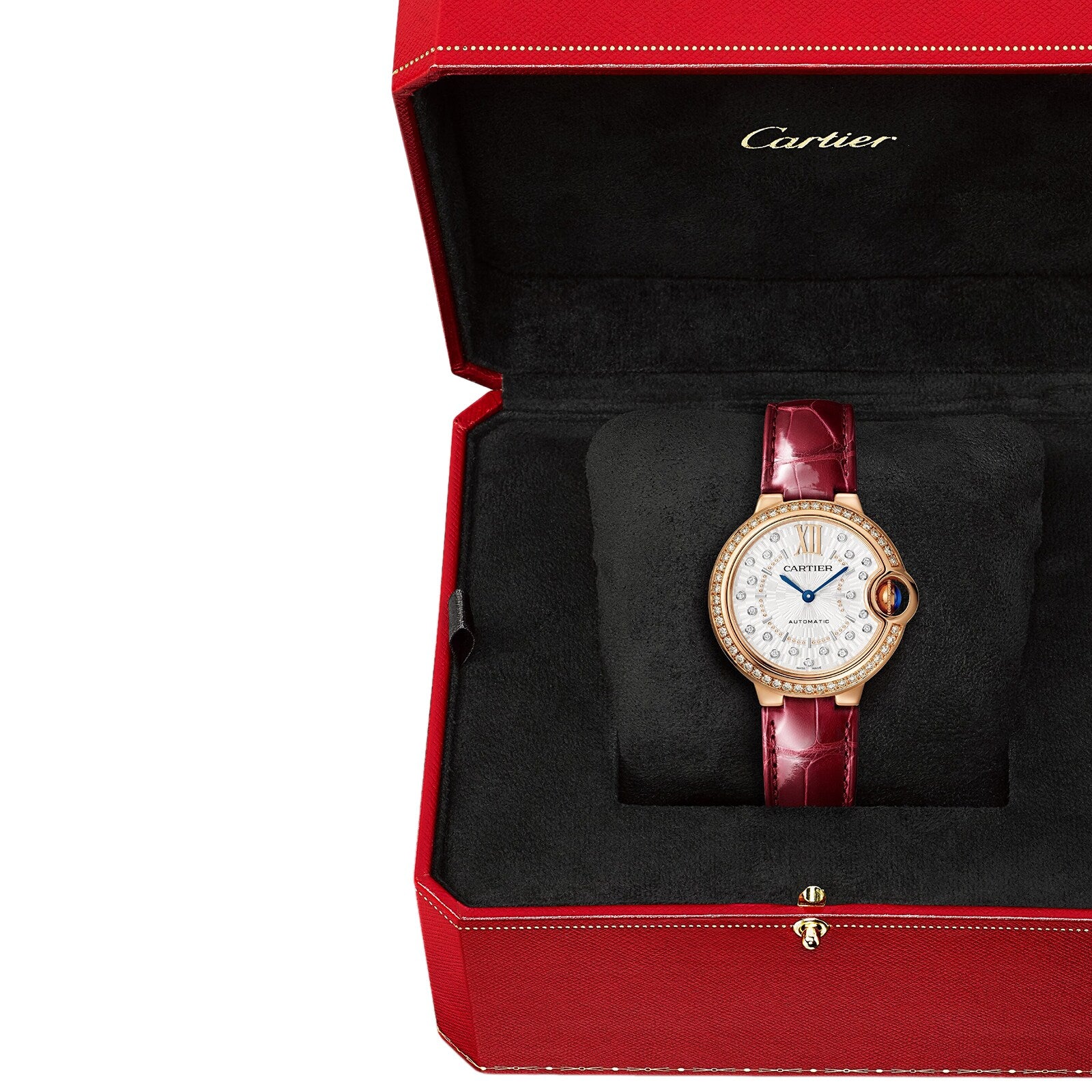 The Ballon Bleu de Cartier watch by Cartier features a diamond-encrusted face and rose gold accents on a red leather strap, elegantly displayed in an open red box lined with black fabric.