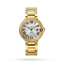 A Cartier Ballon Bleu de Cartier wristwatch, featuring a round face with Roman numerals, blue hands, diamond-set bezel, and yellow gold linked bracelet, is elegantly displayed on a white background.
