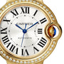Close-up of a Cartier Ballon Bleu de Cartier watch featuring yellow gold, a diamond-set bezel, Roman numeral markers, blue hands, and a crown set with a blue cabochon.