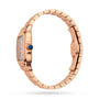 A Cartier Baignoire watch with a rose gold case, rectangular face, blue gemstone crown, and metal bracelet is shown in profile view against a white background.
