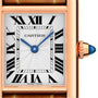 Close-up of the Cartier Tank Louis Cartier watch face featuring Roman numerals, blue sword-shaped hands, a rectangular rose gold case, blue cabochon crown, and an elegant alligator skin strap.