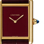 Close-up of the Cartier Tank Louis Cartier wristwatch, featuring an 18K yellow gold rectangular case, burgundy dial, gold hands, blue cabochon crown, and visible CARTIER and SWISS MADE markings.