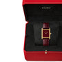 The Cartier Tank Louis Cartier wristwatch, featuring a burgundy leather strap and 18K yellow gold case, is elegantly presented in an open red Cartier box.