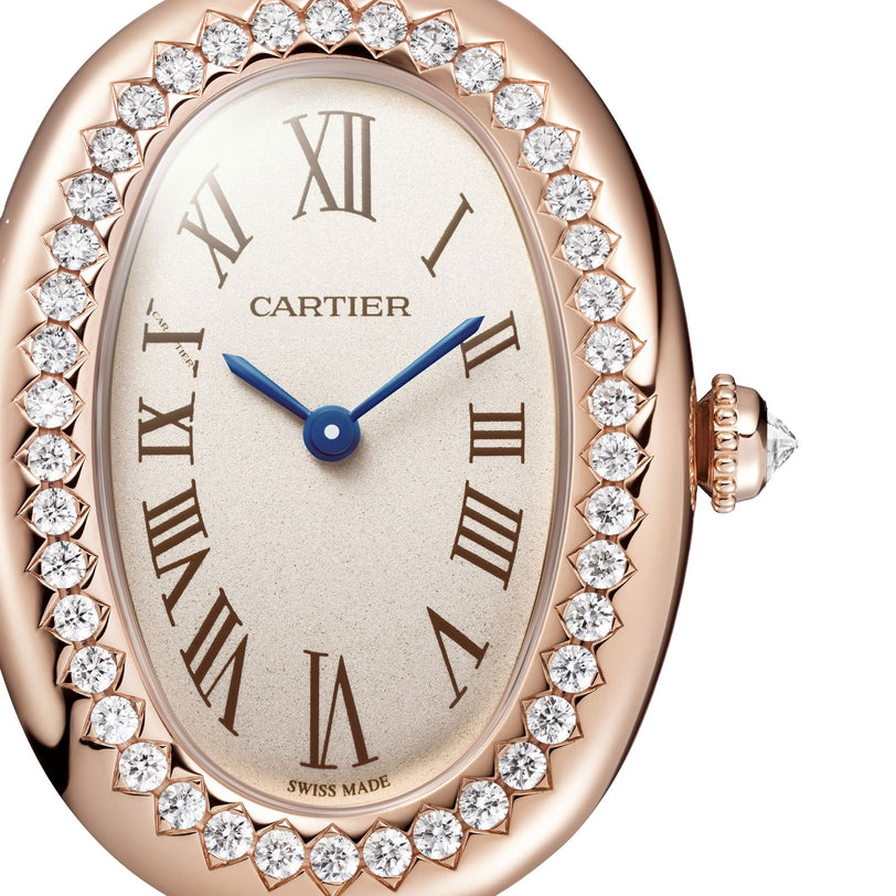 Close-up of the Cartier Baignoire watch featuring Roman numerals, blue hands, and a diamond-encrusted rose gold bezel.