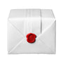 A white folded envelope is sealed with a red wax seal featuring an embossed emblem, echoing the elegance and sophistication of the Santos de Cartier by Cartier.