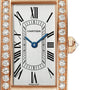 Close-up of the Cartier Tank Américaine watch featuring a rectangular face, rose gold case, diamond-encrusted bezel, Roman numeral markers, and blue hands.