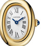 Close-up of the Cartier Baignoire (Size 15) in yellow gold, highlighting its white oval face with black Roman numerals, blue hands, a blue cabochon crown, and precise quartz movement.