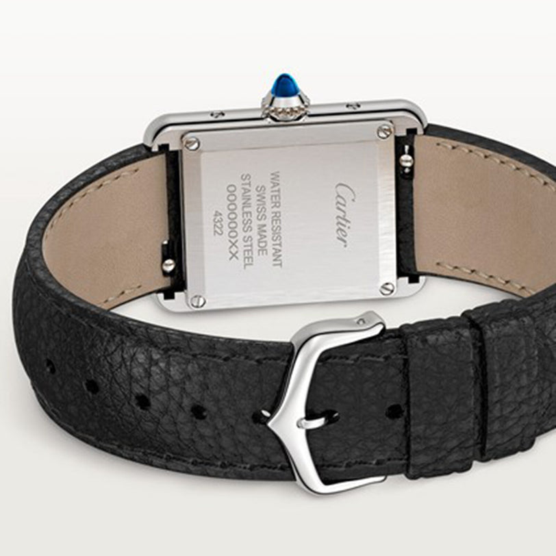 The back view of a Cartier Tank Must de Cartier watch reveals its stainless steel case, black textured leather strap, beaded crown, and engraved specifications.