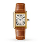 The Cartier Tank Louis Cartier is a rectangular 18K yellow gold watch with a Roman numeral dial, blue hands, date window at 3 o’clock, and brown leather strap, shown on a white background.