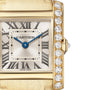 Close-up of the Cartier Tank Française watch, featuring a yellow gold case, Roman numerals, blue hands, and a brilliant-cut diamond-encrusted bezel on the right side of the face.