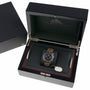 An OMEGA Speedmaster Dark Side of the Moon wristwatch with a brown strap and 9300 calibre movement is displayed in an open black presentation box.