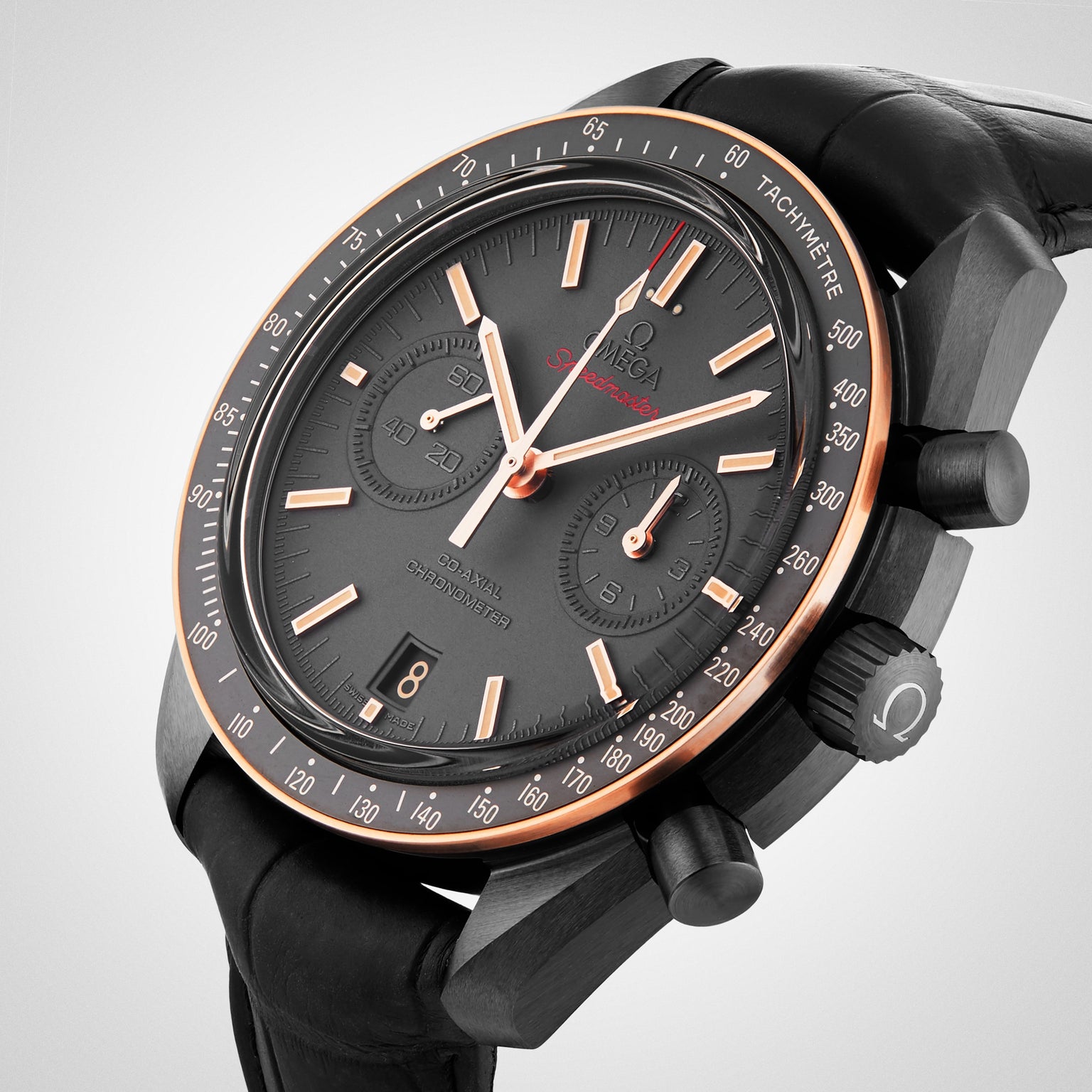 A close-up view of the OMEGA Speedmaster Dark Side Of The Moon Sedna Black, featuring a black ceramic and rose gold case, black leather strap, and chronograph functions.