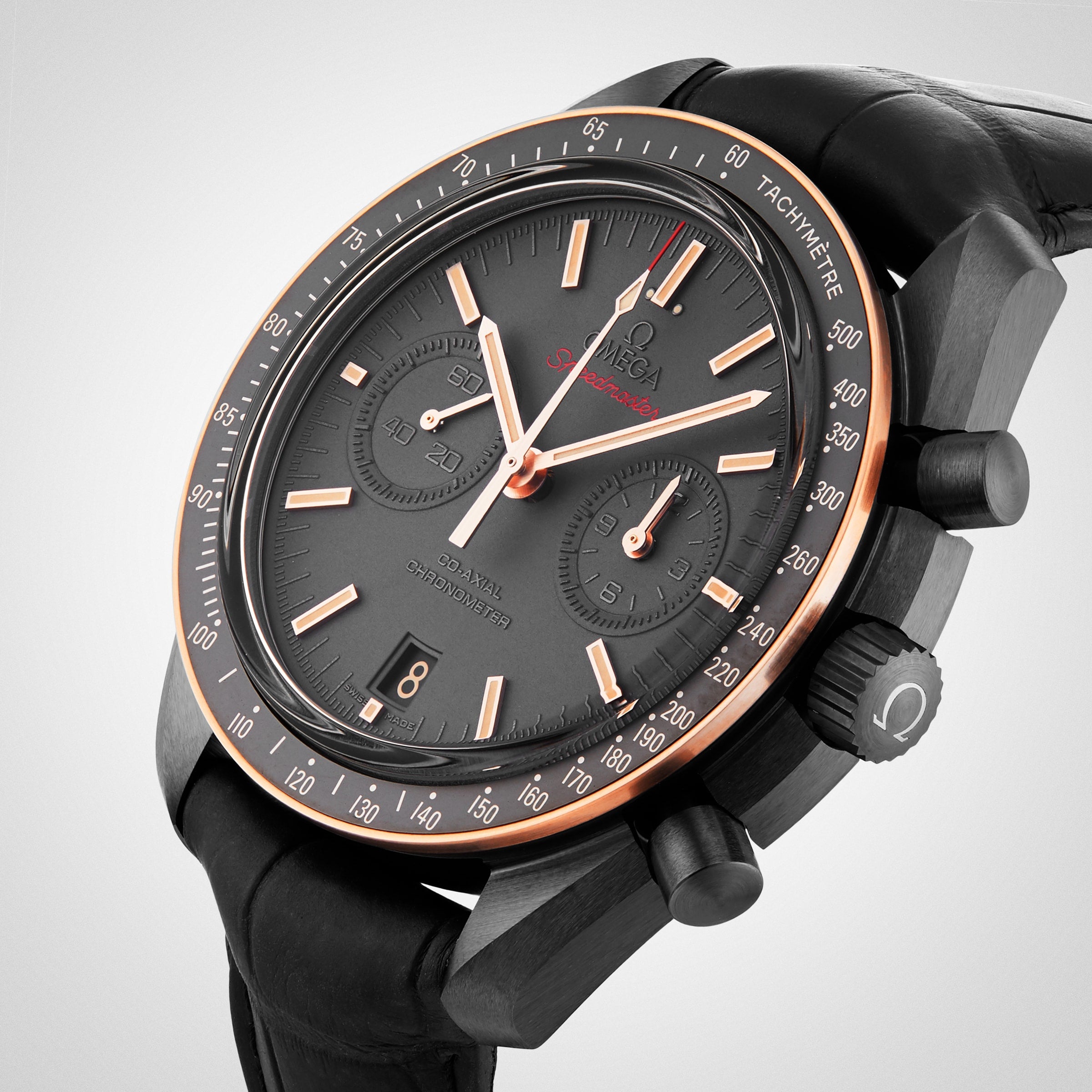 A close-up view of the OMEGA Speedmaster Dark Side Of The Moon Sedna Black, featuring a black ceramic and rose gold case, black leather strap, and chronograph functions.