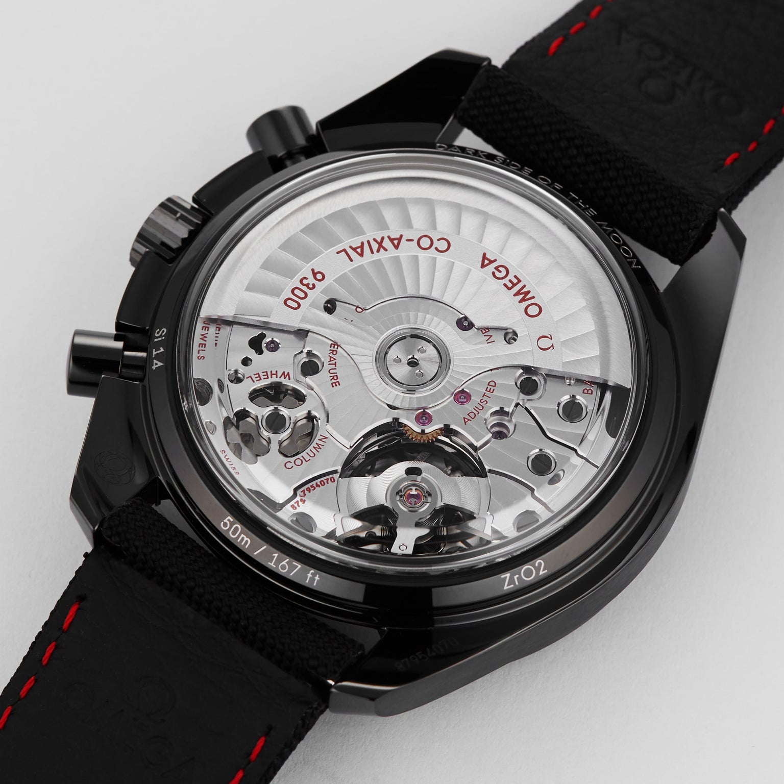 The back view of the OMEGA Speedmaster Dark Side of the Moon Black Black showcases its exposed co-axial 9300 movement with visible gears, engravings, and an all-black leather strap—a striking tribute to lunar exploration.