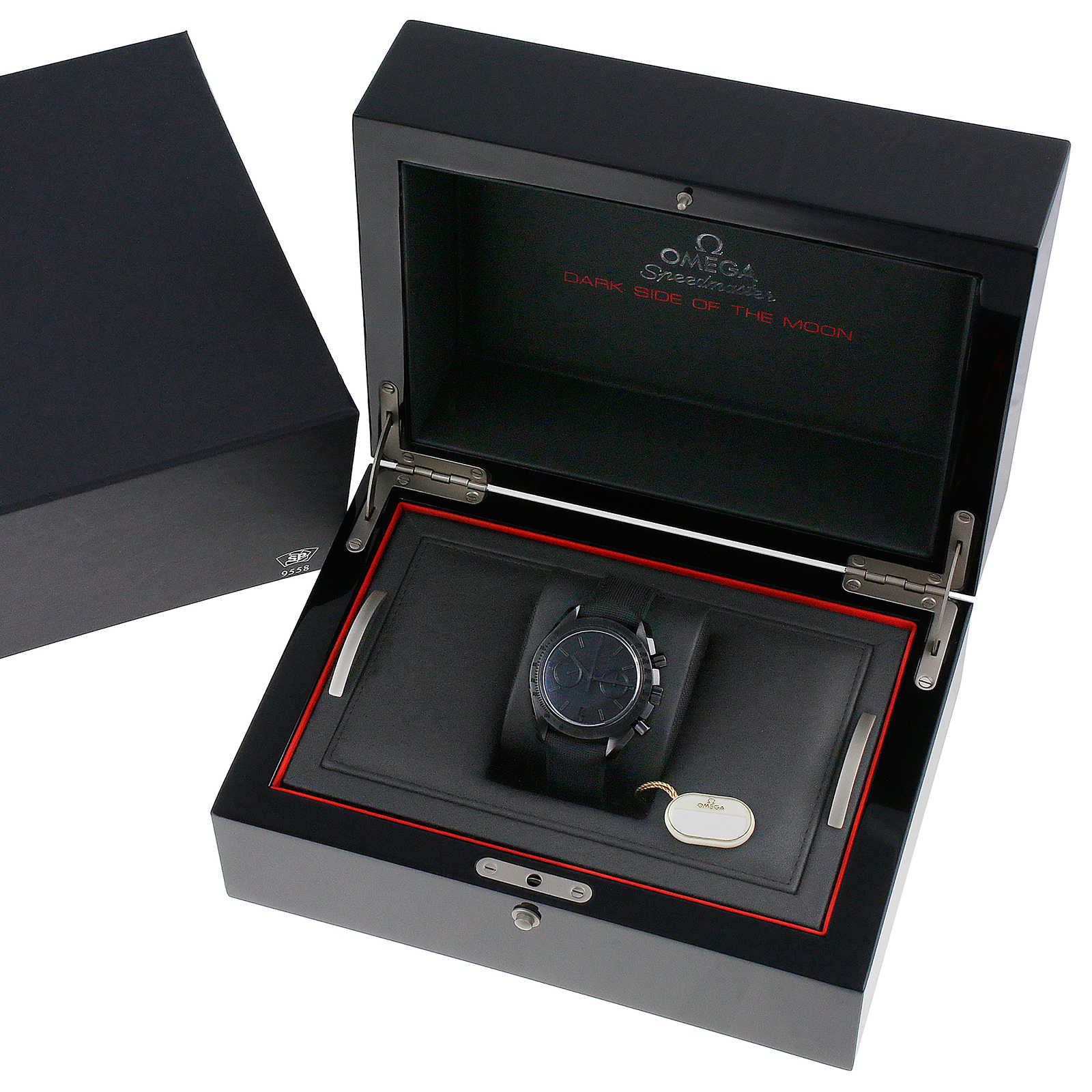 An OMEGA Speedmaster Dark Side of the Moon Black Black wristwatch, inspired by Apollo 8, displayed in a black presentation box with a tag attached.
