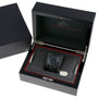 An OMEGA Speedmaster Dark Side of the Moon Black Black wristwatch, inspired by Apollo 8, displayed in a black presentation box with a tag attached.