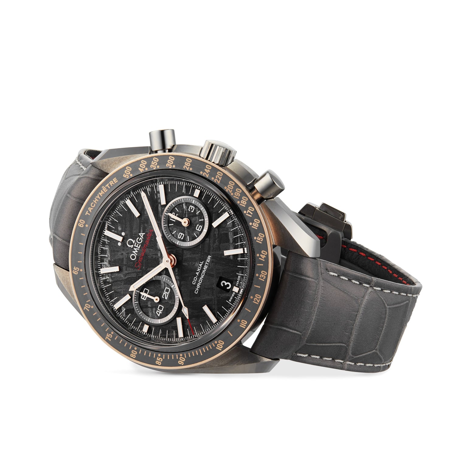 The OMEGA Speedmaster Dark Side of the Moon Meteorite features a black and gold bezel, black chronograph dial, grey alligator leather strap, and a ceramic case for added sophistication.