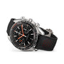 The OMEGA Speedmaster Racing features a stainless steel case, black dial with chronograph subdials and date display, Master Chronometer 9900 calibre movement, and a black perforated leather strap with red accents.