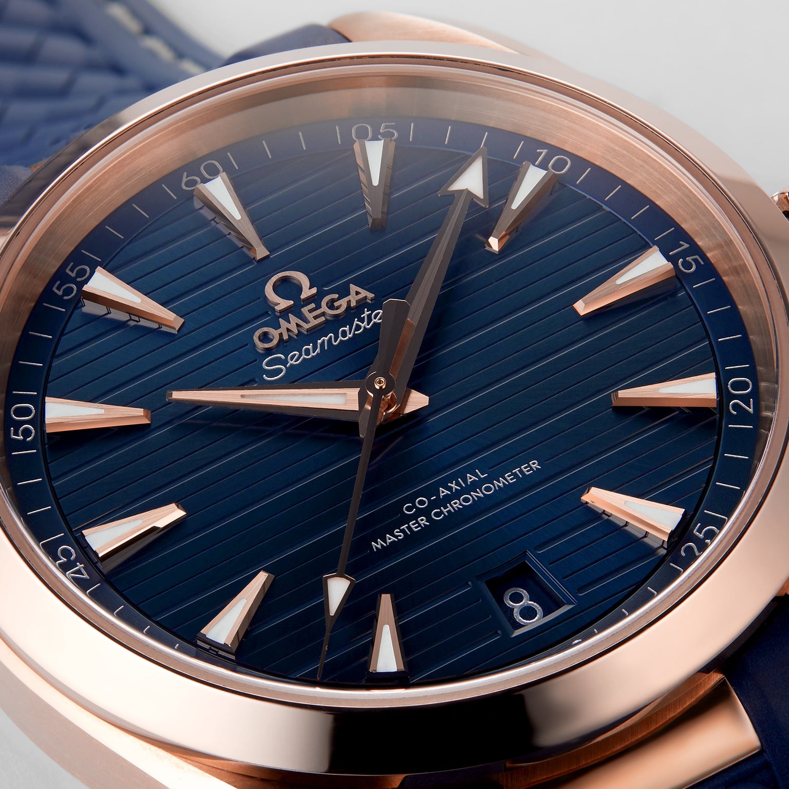 Close-up of the OMEGA Seamaster Aqua Terra 150M featuring a blue textured dial, gold hour markers and hands, date window at 6 o’clock, and a Master Chronometer-certified 8800 calibre movement.