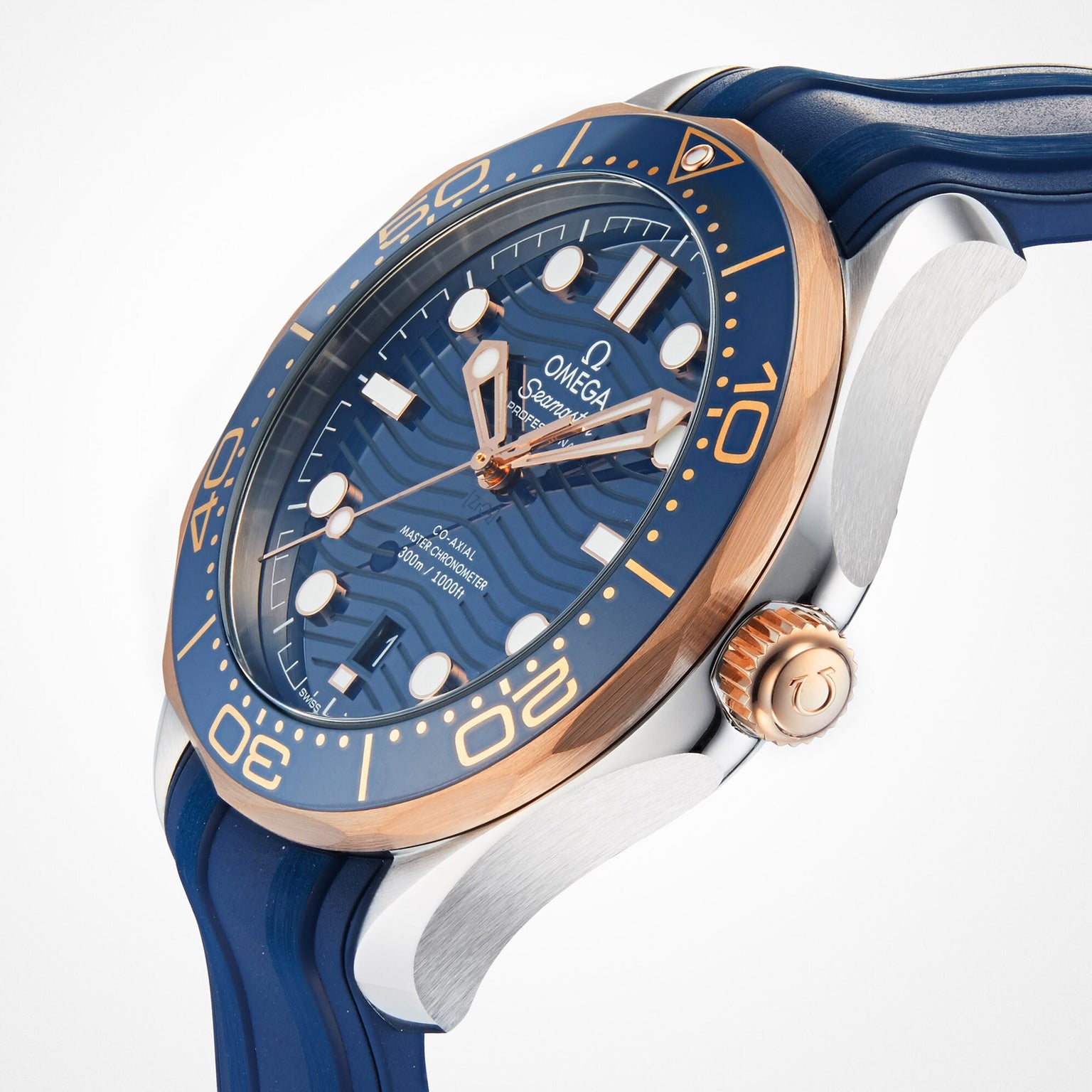 The OMEGA Seamaster Diver 300M wristwatch features a blue dial and strap, rose gold bezel and accents, and the OMEGA Co-Axial Master Chronometer Calibre 8800 movement, displayed at an angle on a white background.