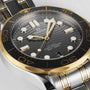 Close-up of the OMEGA Seamaster Diver 300M, showcasing a black wavy dial, gold and steel bezel, luminous hour markers, and a two-tone stainless steel and gold bracelet.