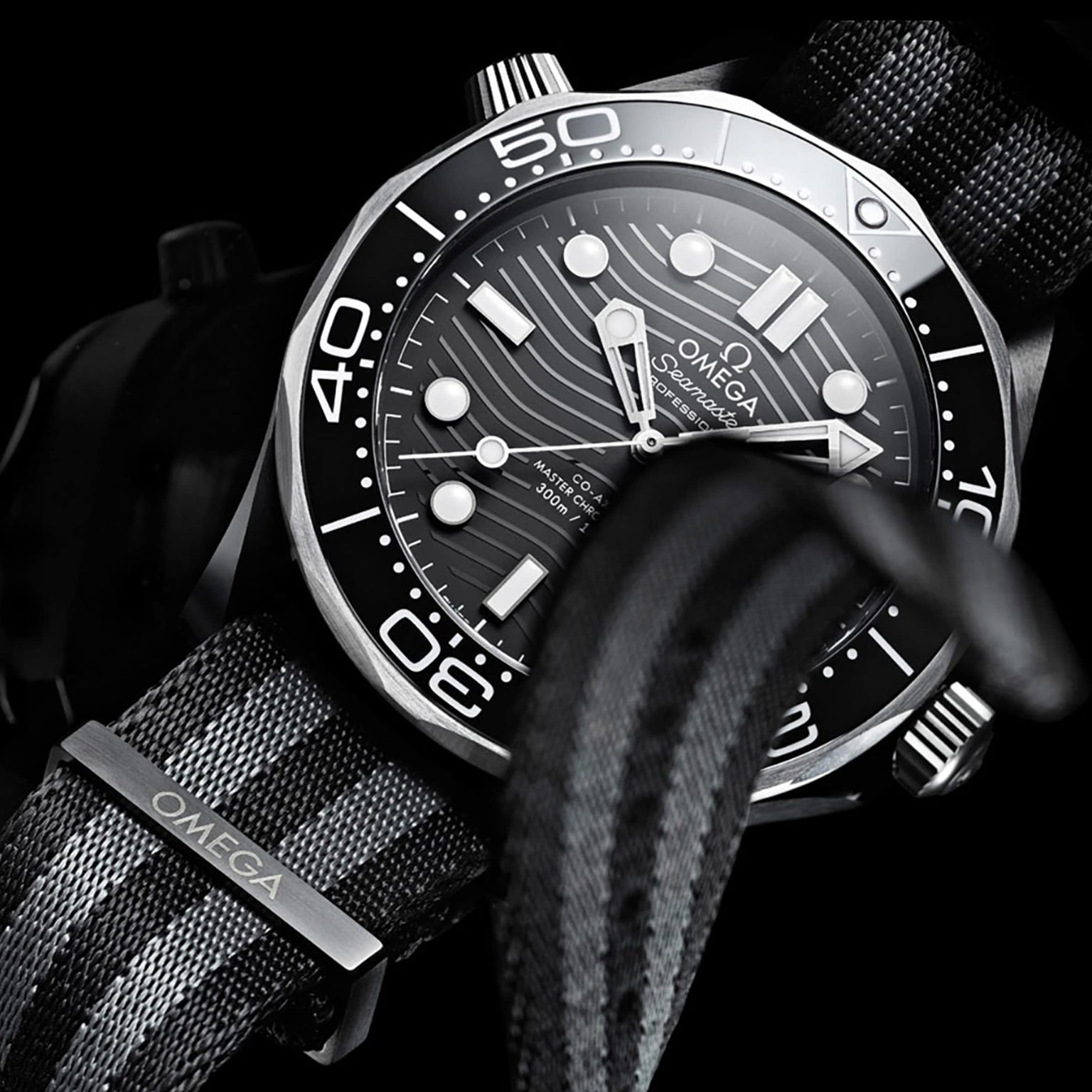Close-up of the OMEGA Seamaster Diver 300M with a black and grey NATO strap, black dial, white markers, and rotating bezel—a true Master Chronometer dive watch by OMEGA.