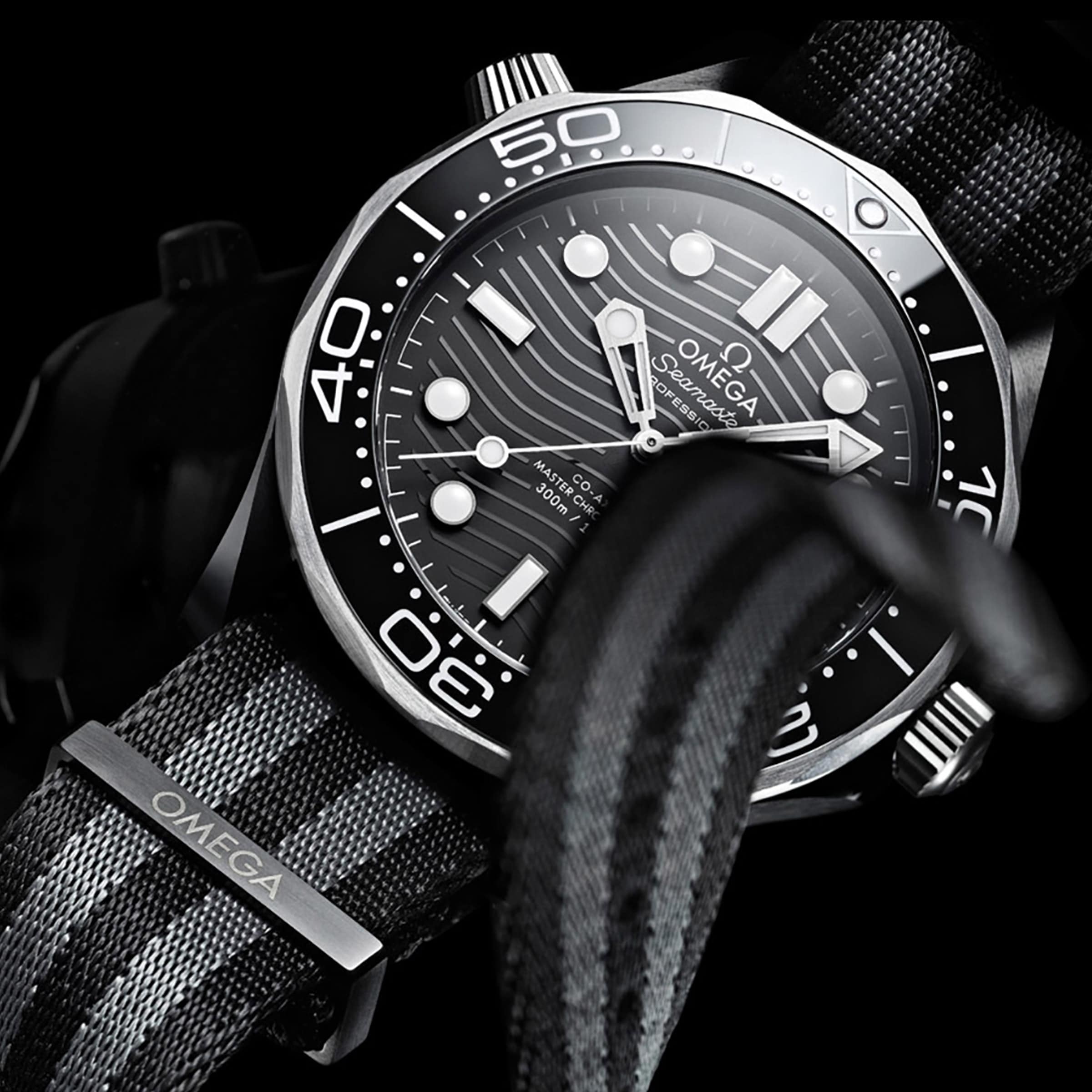 Close-up of the OMEGA Seamaster Diver 300M with a black and grey NATO strap, black dial, white markers, and rotating bezel—a true Master Chronometer dive watch by OMEGA.