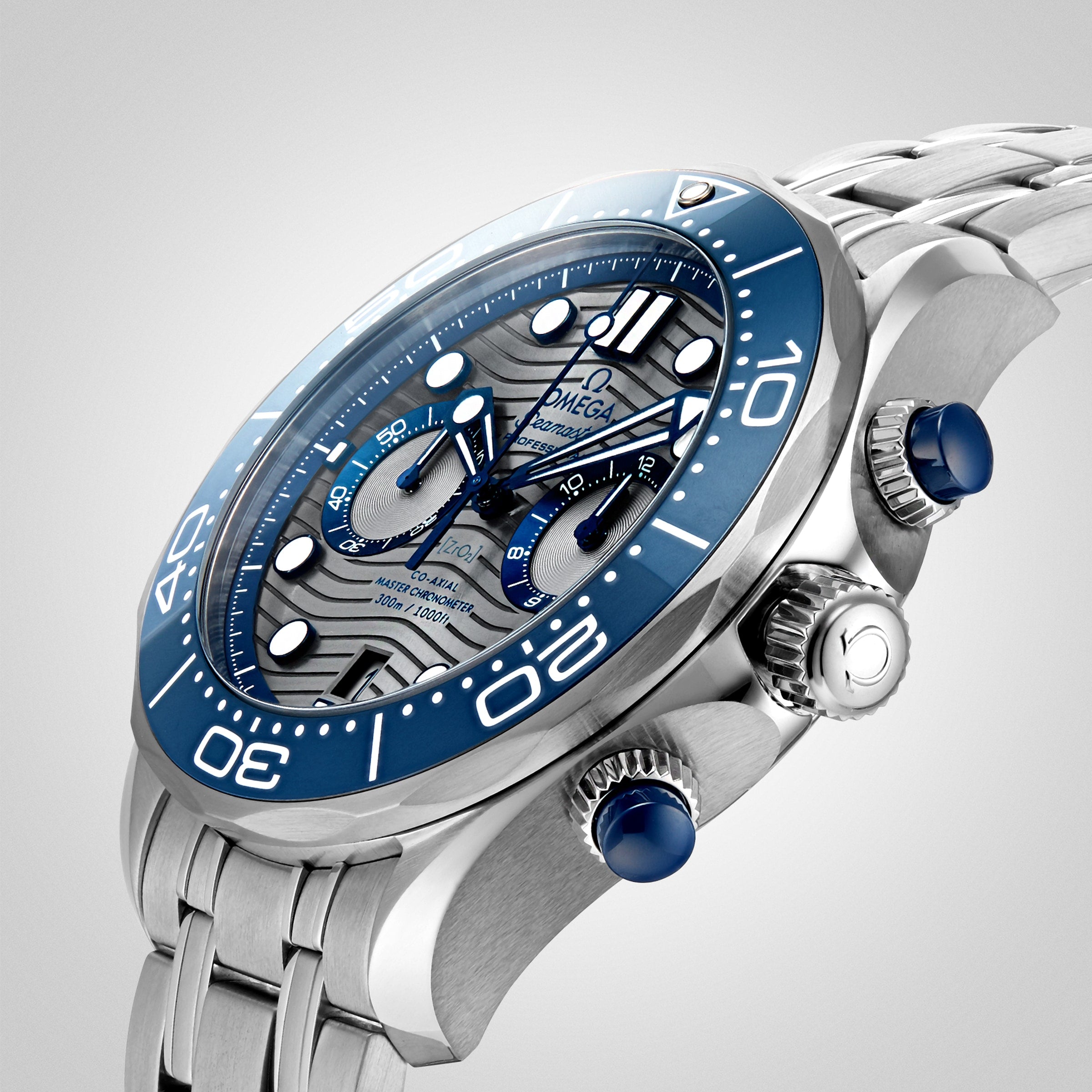 A close-up of an OMEGA Seamaster Diver 300M watch chronograph featuring a blue bezel, blue subdials, and a stainless steel bracelet on a plain background—a timepiece famously associated with James Bond.